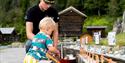 little boy locks a boat on the miniature version of the telemark canal in the canal park at Vest-Telemark Museum in Eidsborg