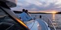 couple sitting on deck and enjoying the sunset