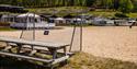 sandstrand med fotballmål og rastebenk på Kilen Camping