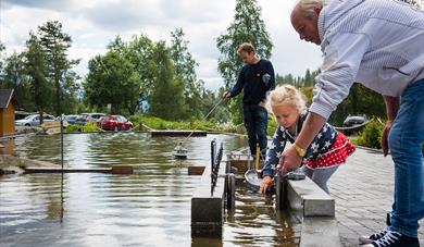 jente sluser en båt på miniatyrutgaven av telemarkskanalen på kanalparken på Vest-Telemark Museum i Eidsborg
