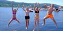 Ungdom som hopper og bader fra brygge på Nesøya Marina Gjestebrygge i Notodden. Foto
