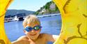 Gutt med svømmebriller og badering ved Bystranda og Nesøya Marina, i Notodden. Foto