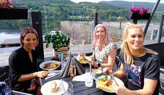 Tre kvinner spiser mat og koser seg på uteserveringen til Dany's Café i Bok & Blueshuset i Notodden. Foto