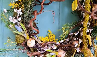 A Spring wreath made with moss, flowers and foulage