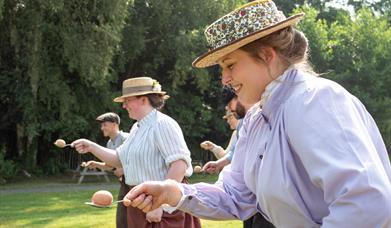 Women in costume compete in egg'n'spoon race at Blists Hill Victorian Town.