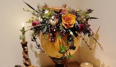 an example of a decorated pumpkin with flowers and foliage.