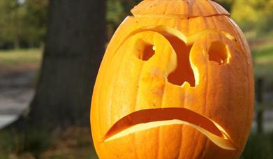 a sad face carved into a Halloween pumpkin