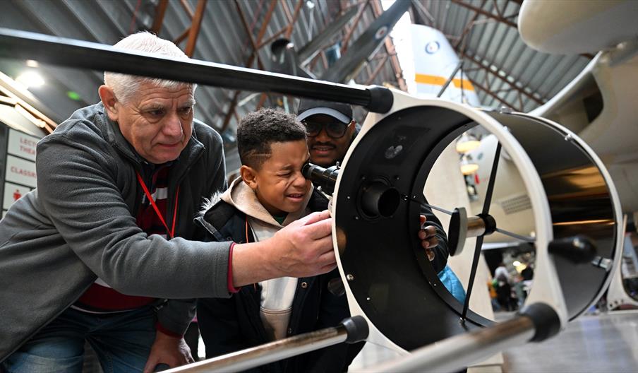 A child looking into a telescope at RAF Midlands