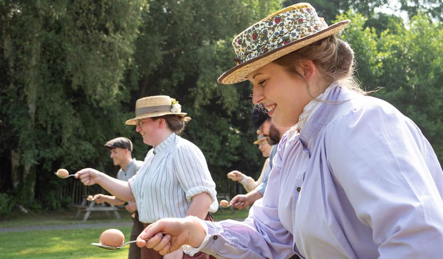 Women in costume compete in egg'n'spoon race at Blists Hill Victorian Town.