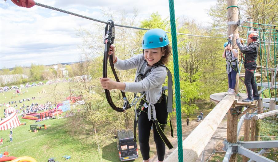 Young girl enjoying using the high ropes course.