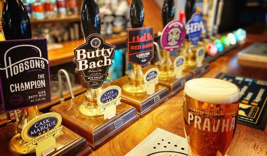 A pint of lager on the bar of a pub