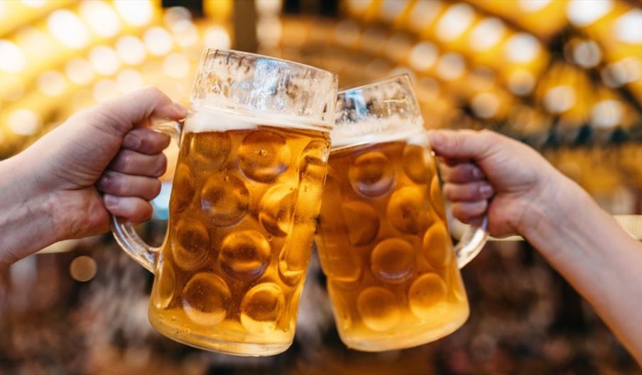 two beer tankards clinked together