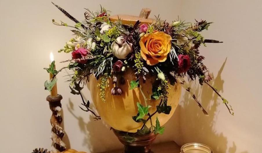 an example of a decorated pumpkin with flowers and foliage.