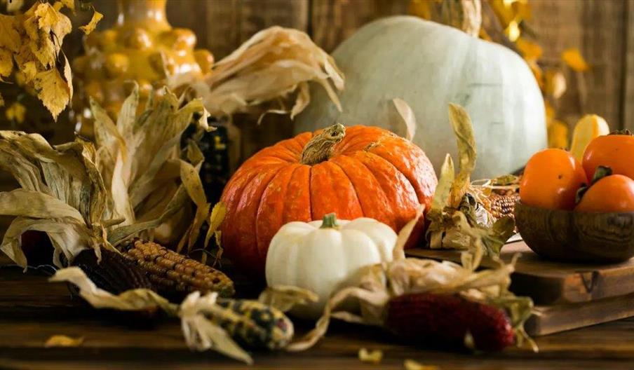 Ceramic pumpkins and leaves surrounding.