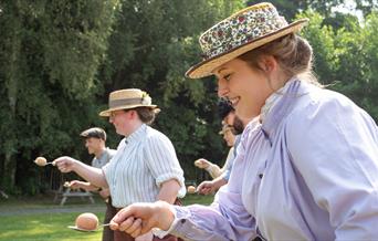 Women in costume compete in egg'n'spoon race at Blists Hill Victorian Town.