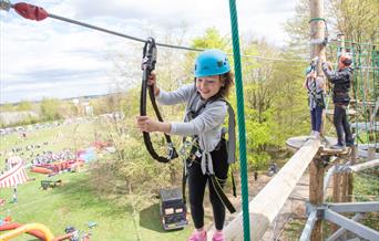 Young girl enjoying using the high ropes course.
