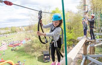 Young girl enjoying using the high ropes course.