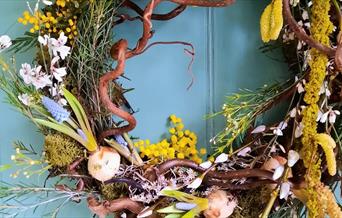 A Spring wreath made with moss, flowers and foulage