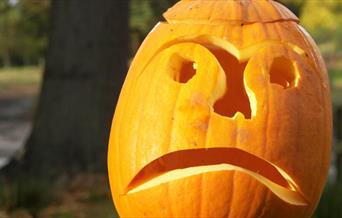 a sad face carved into a Halloween pumpkin