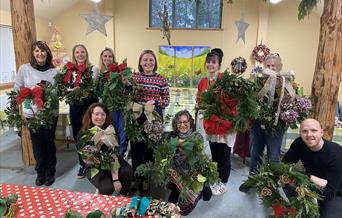 Wreath making participants with their finished wreaths