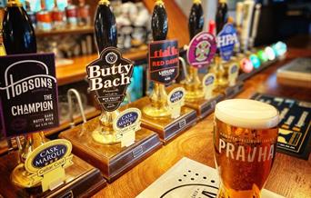 A pint of lager on the bar of a pub