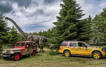 Ranger vehicles and dinosaur shown in the grounds