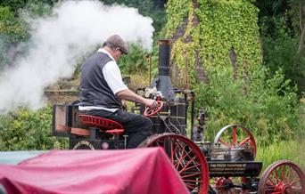 A man is pictured driving a steam engine.