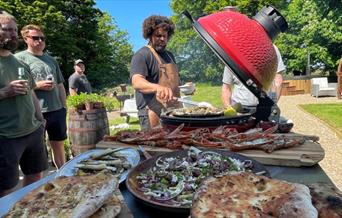 Adam Purnell cooking on open flame