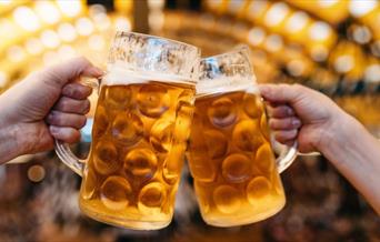 two beer tankards clinked together