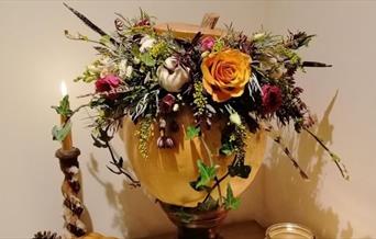 an example of a decorated pumpkin with flowers and foliage.
