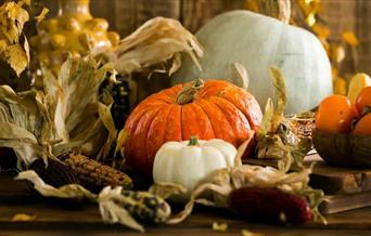 Ceramic pumpkins and leaves surrounding.