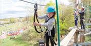 Young girl enjoying using the high ropes course.