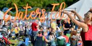 Large bubble blower with Waters Edge Festival sign in the background