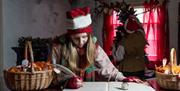Child dressed as an elf writing in a book.