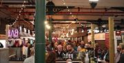 Customers eating and drinking at a late-night opening at Wellington Market.