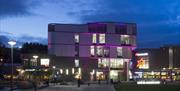 Exterior of Southwater Library illuminated in with purple lights