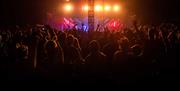 Festival goers inside tent dancing to live music