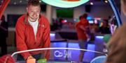 A man playing air hockey at Tenpin