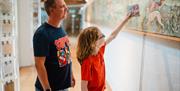 A father and son taking part in an interactive tile trail at Jackfield Tile Museum.