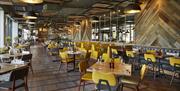 Wildwood Telford restaurant interior featuring yellow chairs and tables.