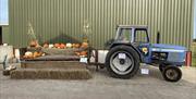 Photo Opportunity section of attraction with blue tractor and pallet chair decorated with Pumpkins