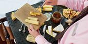 waitress serving cheese from cheese board