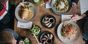 a range of wagamama dishes including donburi, raisukaree, yaki soba and katsu curry. sides include gyoza and edamame beans.