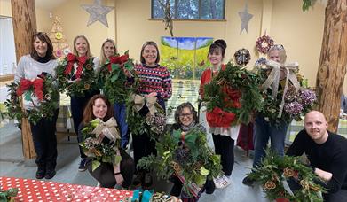 Wreath making participants with their finished wreaths