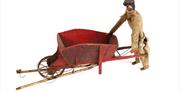 A wheel barrow, one of the puppets flown across the river