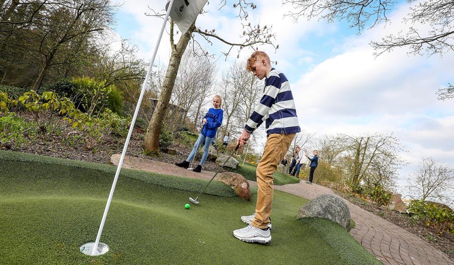 Young people playing adventure golf on a sunny day