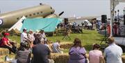 Visitors sat on hay bales listening to music at the RAF Cosford airshow