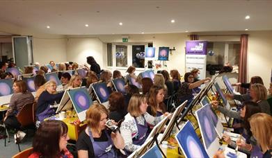 a sip and paint class taking part in an event