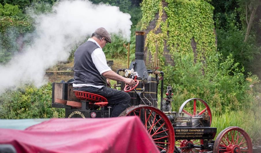 A man is pictured driving a steam engine.