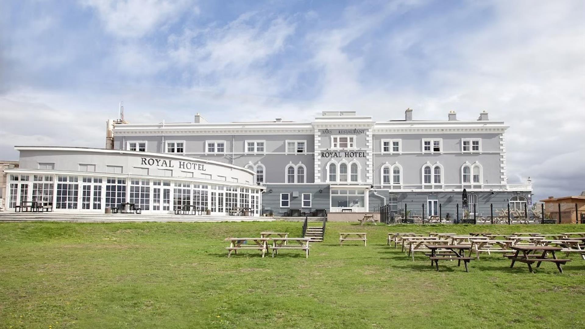 A palatial-looking Georgian hotel with an expansive lawn in the foreground